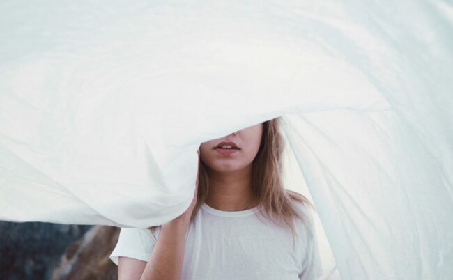 femme qui cache son visage avec un draps blanc